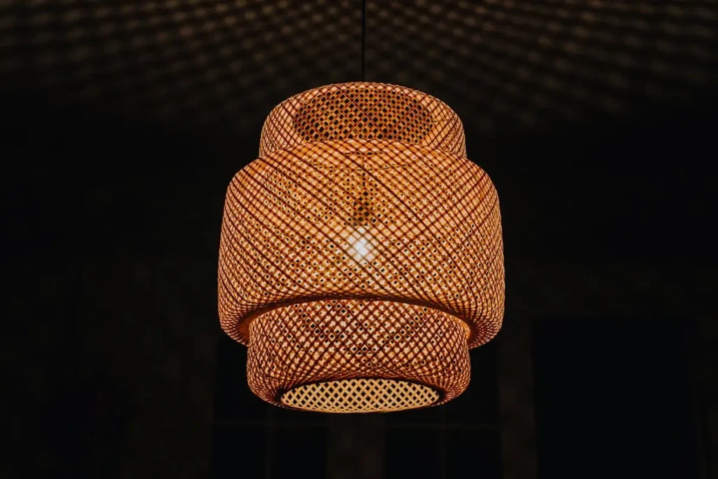 Close-up of a woven rattan pendant light fixture with soft, warm glow