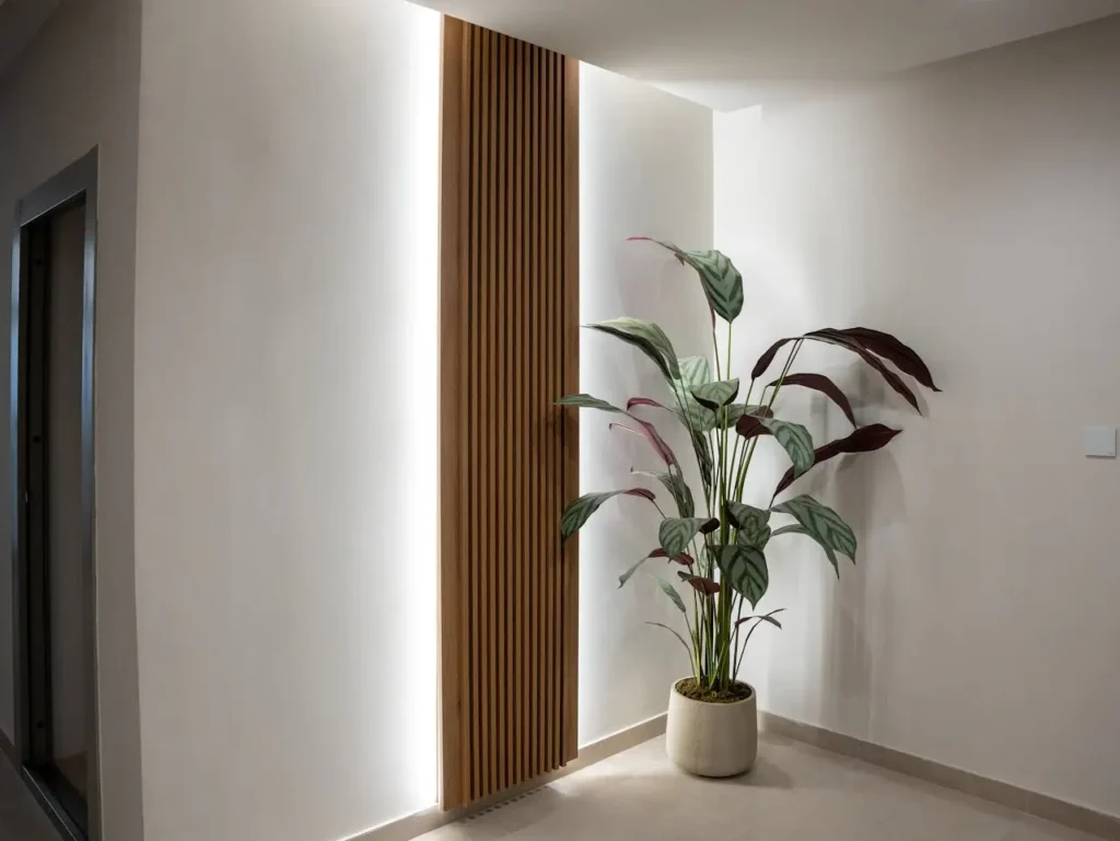 Architectural linear lighting in a monochromatic smart home decor hallway, emphasizing light grey texture.
