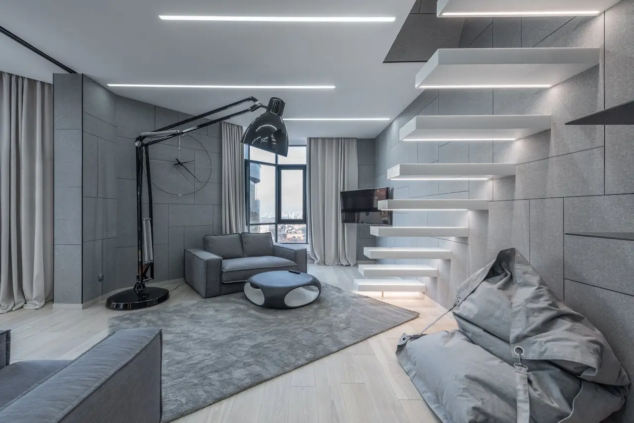 Modern living room featuring elegant monochromatic smart home decor with layered grey textiles and integrated architectural lighting
